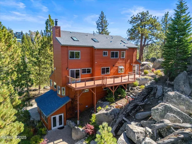 an aerial view of a house with a mountain