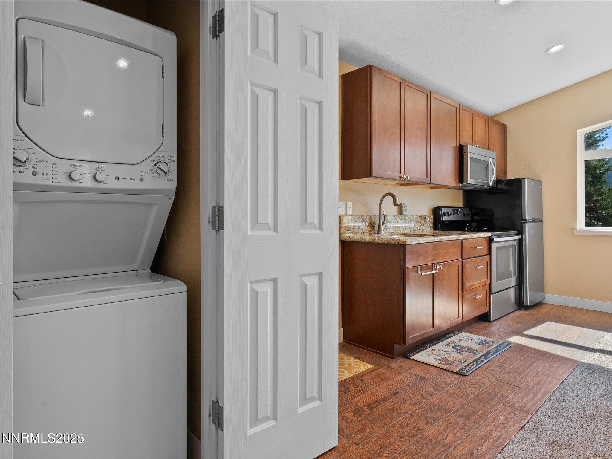 689 Tina Court Stateline, NV 89449 - Photo 85 of 102 a kitchen with stainless steel appliances granite countertop a stove a sink and a refrigerator with wooden floors