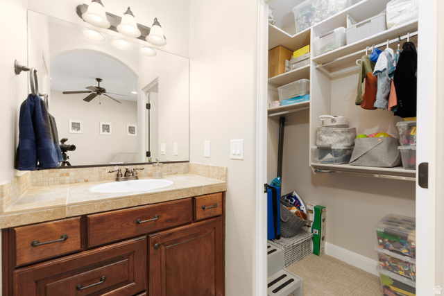1257 West 2320 South St. George, UT 84770 - Photo 26 of 55 Bathroom vanity featuring an integrated sink, tiled countertop, and wood-finish cabinetry
