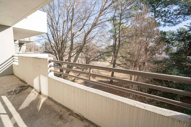 a view of a balcony with wooden floor and fence