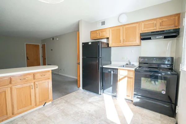 a kitchen with stainless steel appliances granite countertop a refrigerator and a stove top oven