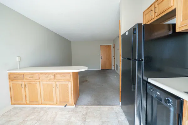 a view of a refrigerator in kitchen and a sink