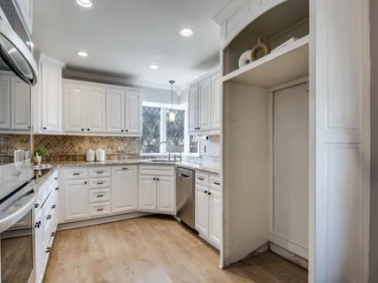 a kitchen with granite countertop white cabinets and white appliances