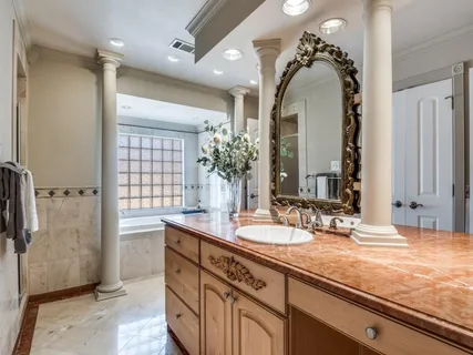 a bathroom with a granite countertop sink a large mirror and a shower