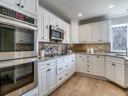 a kitchen with stainless steel appliances granite countertop a stove microwave and cabinets