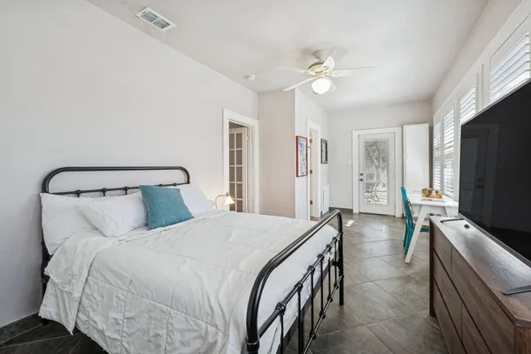 a bedroom with a bed and a flat tv screen on dresser