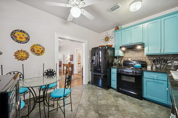 a kitchen with stainless steel appliances granite countertop a refrigerator and a stove top oven