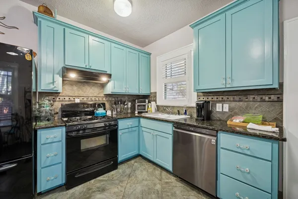 a kitchen with granite countertop stainless steel appliances and cabinets