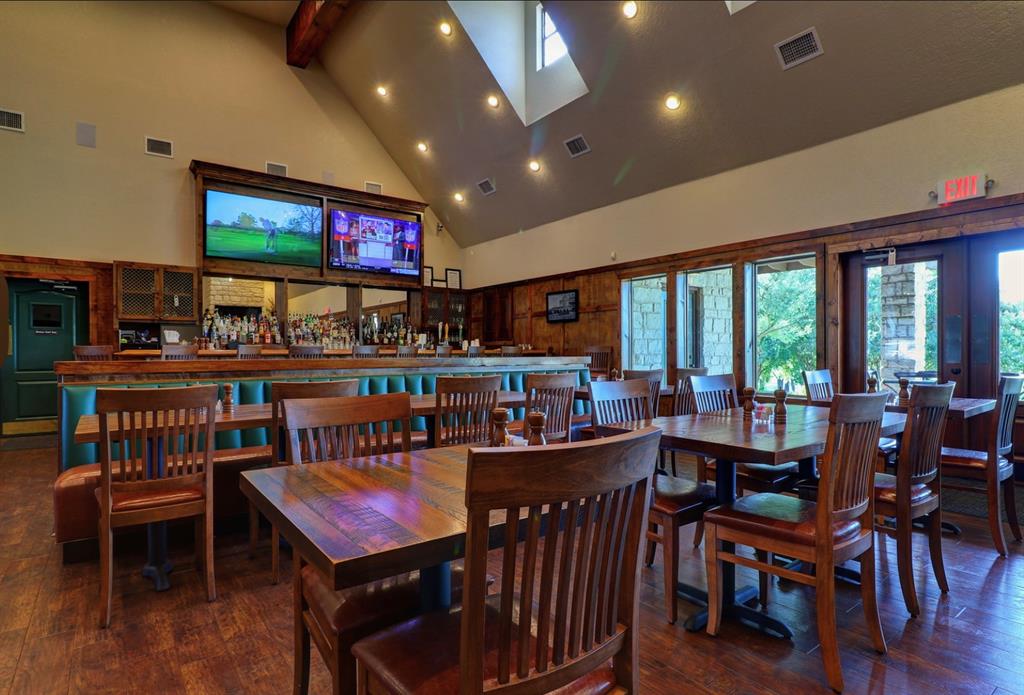 1377 Spring Valley Trail Whitney, TX 76692 - Photo 12 of 34 a living room with furniture a flat screen tv and floor to ceiling window