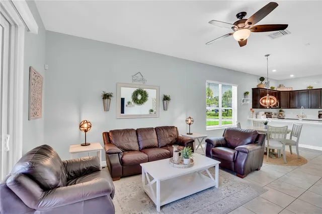 a living room with furniture a ceiling fan and a window