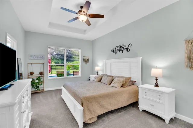 a bedroom with a large bed and a flat tv screen on dresser