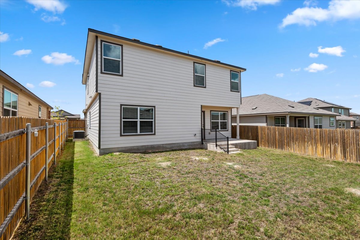 448 Perfect World Loop Jarrell, TX 76537 - Photo 7 of 40 A spacious yard perfect for outdoor enjoyment behind a contemporary two-story residence.
