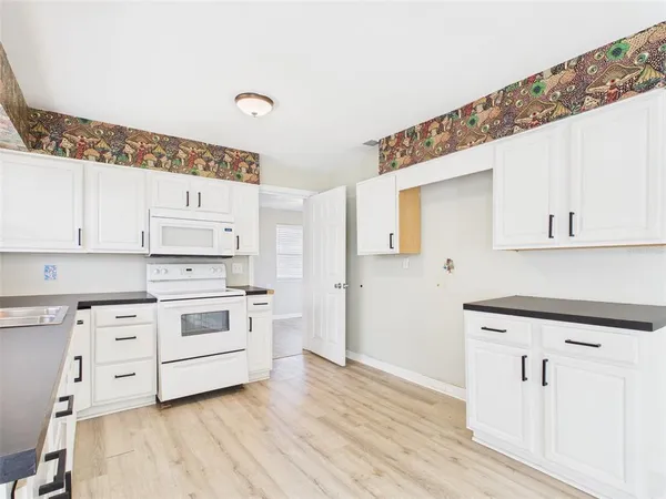 a kitchen with cabinets appliances a sink and a window