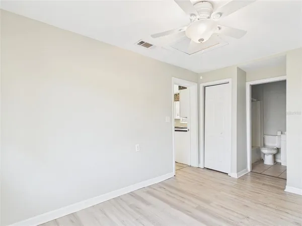 an empty room with a window and a fan
