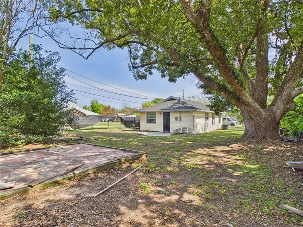 a view of a house with a yard and potted plants