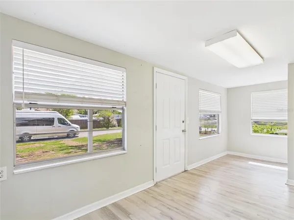 a view of a room with wooden floor and windows