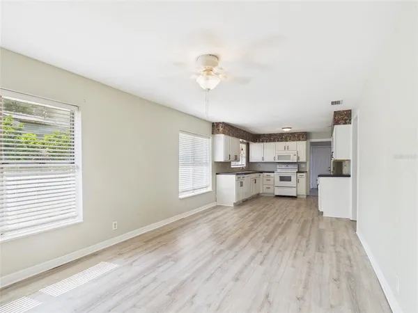 a view of a kitchen with wooden floor and electronic appliances