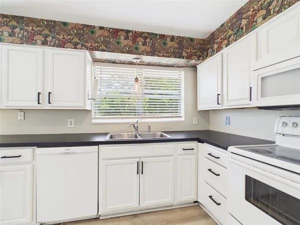 a kitchen with white cabinets and white appliances