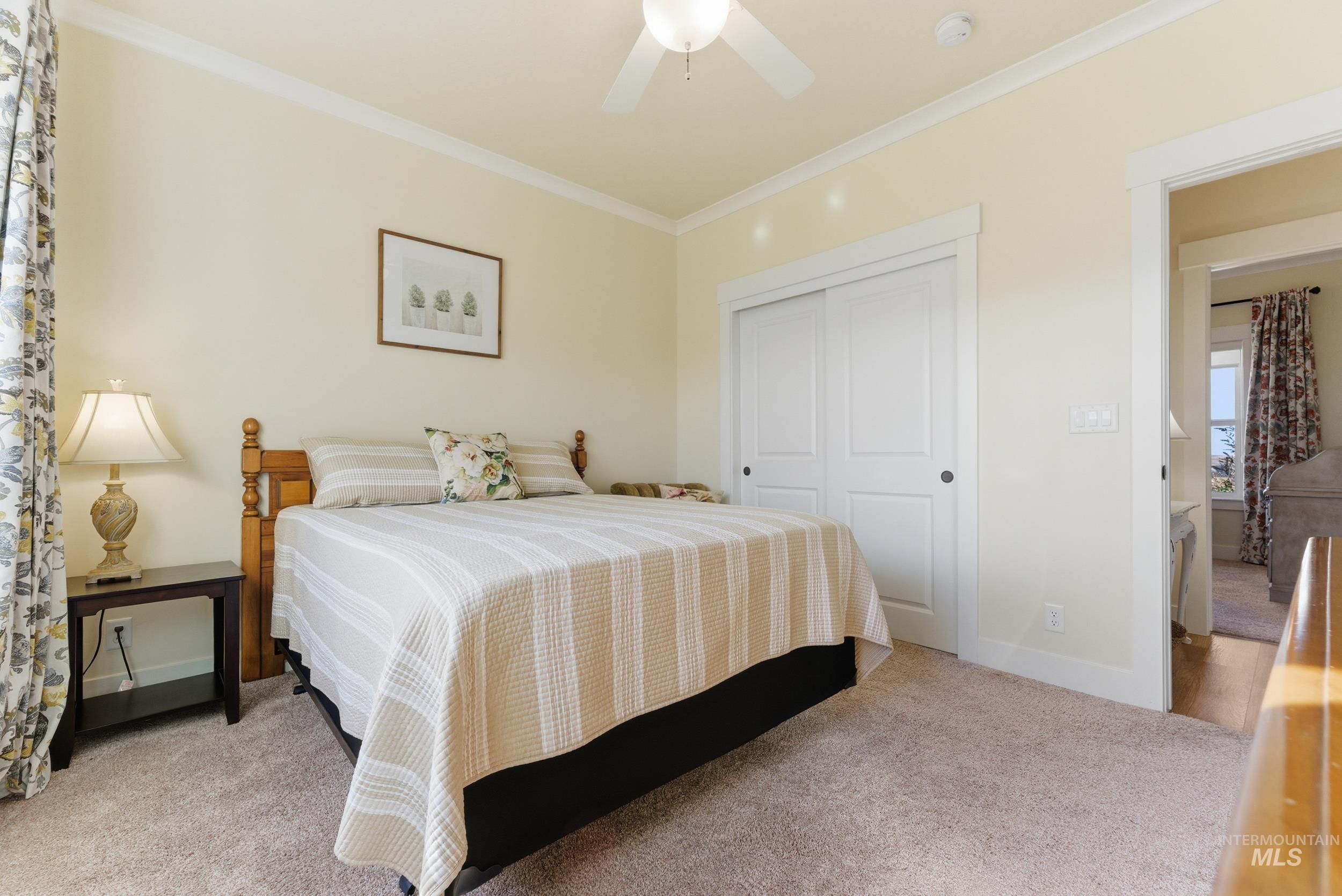 5800 Partridge Peak Avenue Caldwell, ID 83607 - Photo 28 of 50 Bedroom featuring crown molding, light colored carpet, a closet, and a ceiling fan