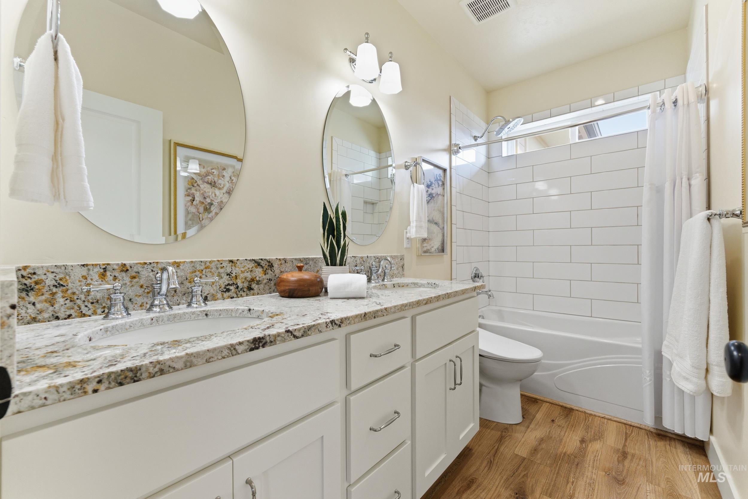 5800 Partridge Peak Avenue Caldwell, ID 83607 - Photo 29 of 50 Bathroom with double vanity, shower / bath combination with curtain, and light wood-type flooring