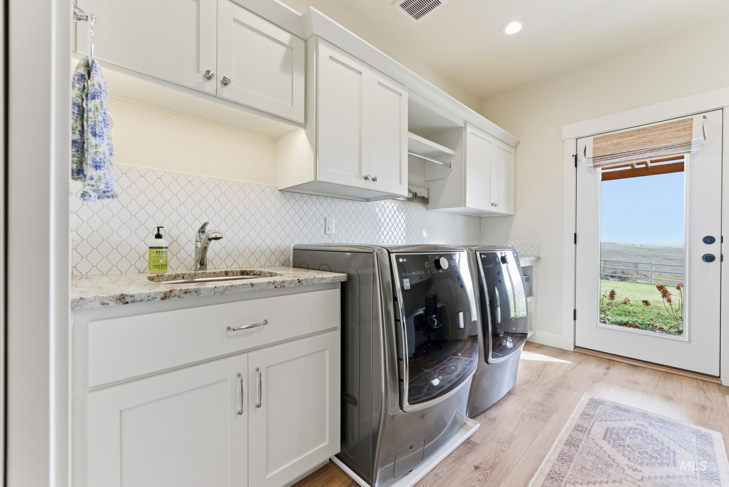 5800 Partridge Peak Avenue Caldwell, ID 83607 - Photo 32 of 50 Laundry area featuring light wood-style flooring, separate washer and dryer, recessed lighting, and cabinet space