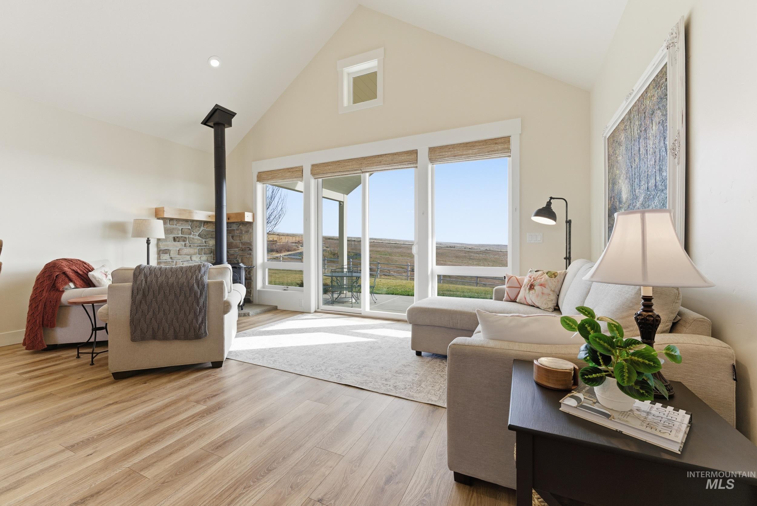 5800 Partridge Peak Avenue Caldwell, ID 83607 - Photo 8 of 50 Living room with a wood stove, a high ceiling, and light wood-type flooring