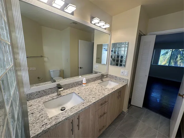 a bathroom with a double vanity sink and a mirror