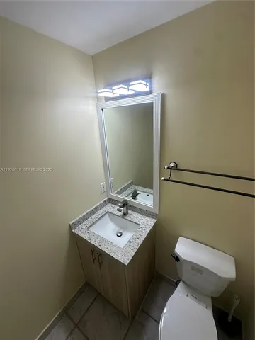 a bathroom with a sink a toilet and mirror