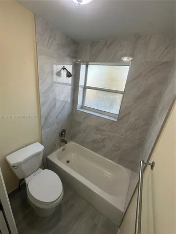 a bathroom with a toilet and a bathtub
