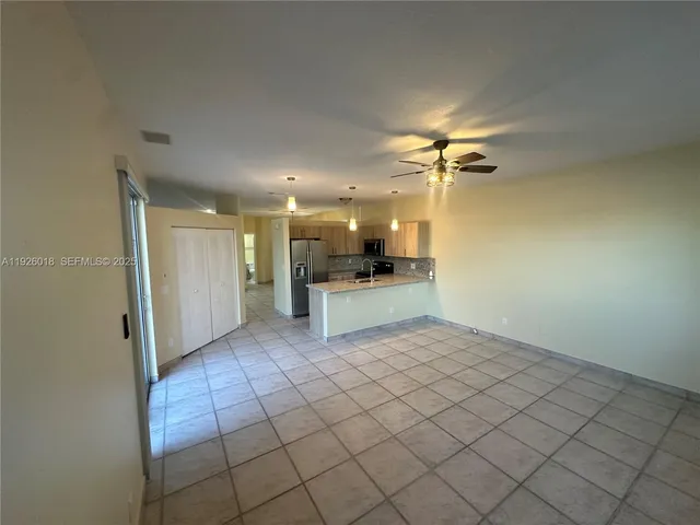 a view of a kitchen with a sink and a refrigerator