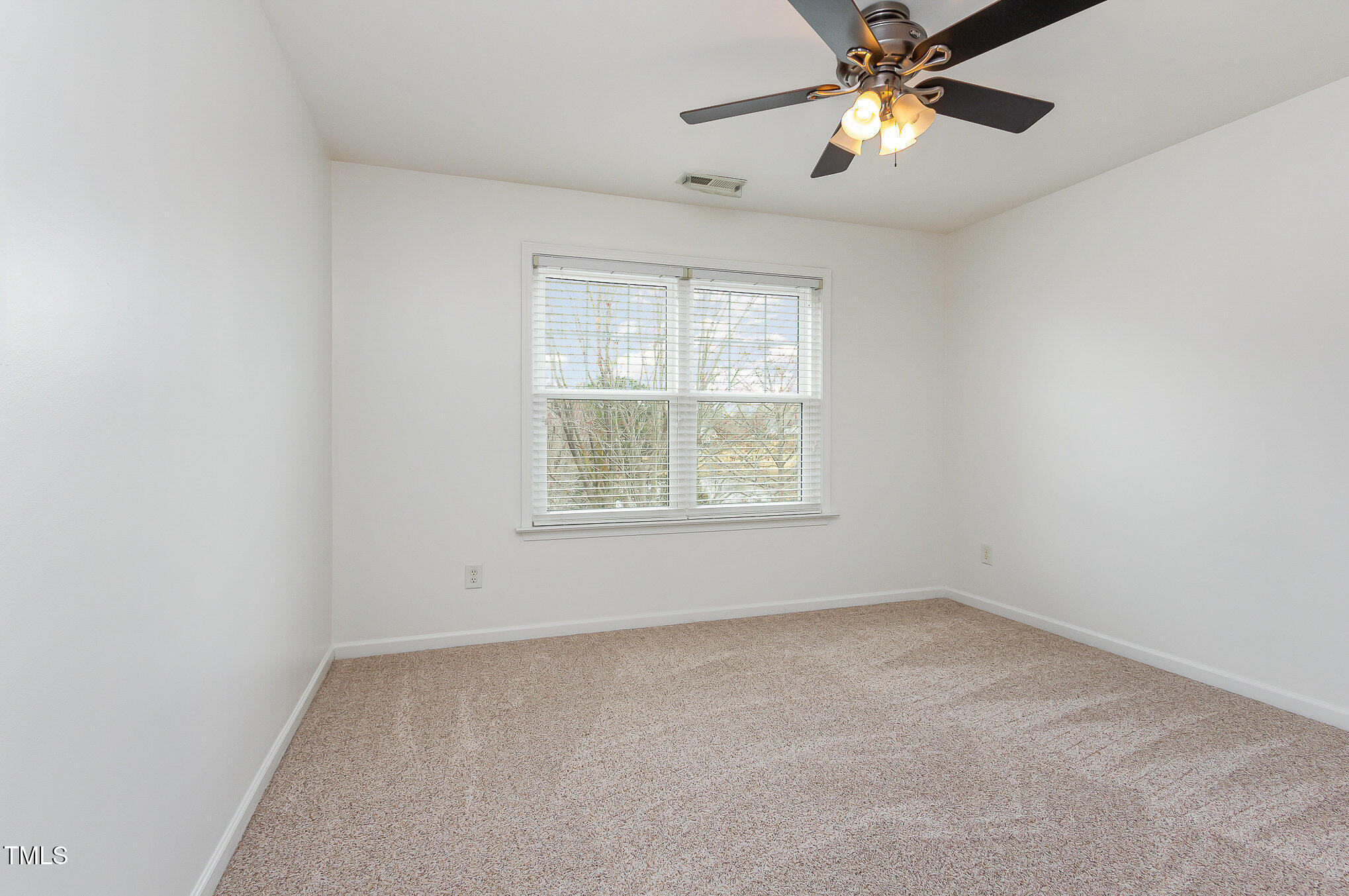 405 Challenge Road Raleigh, NC 27603 - Photo 15 of 24 an empty room with a window and a fan