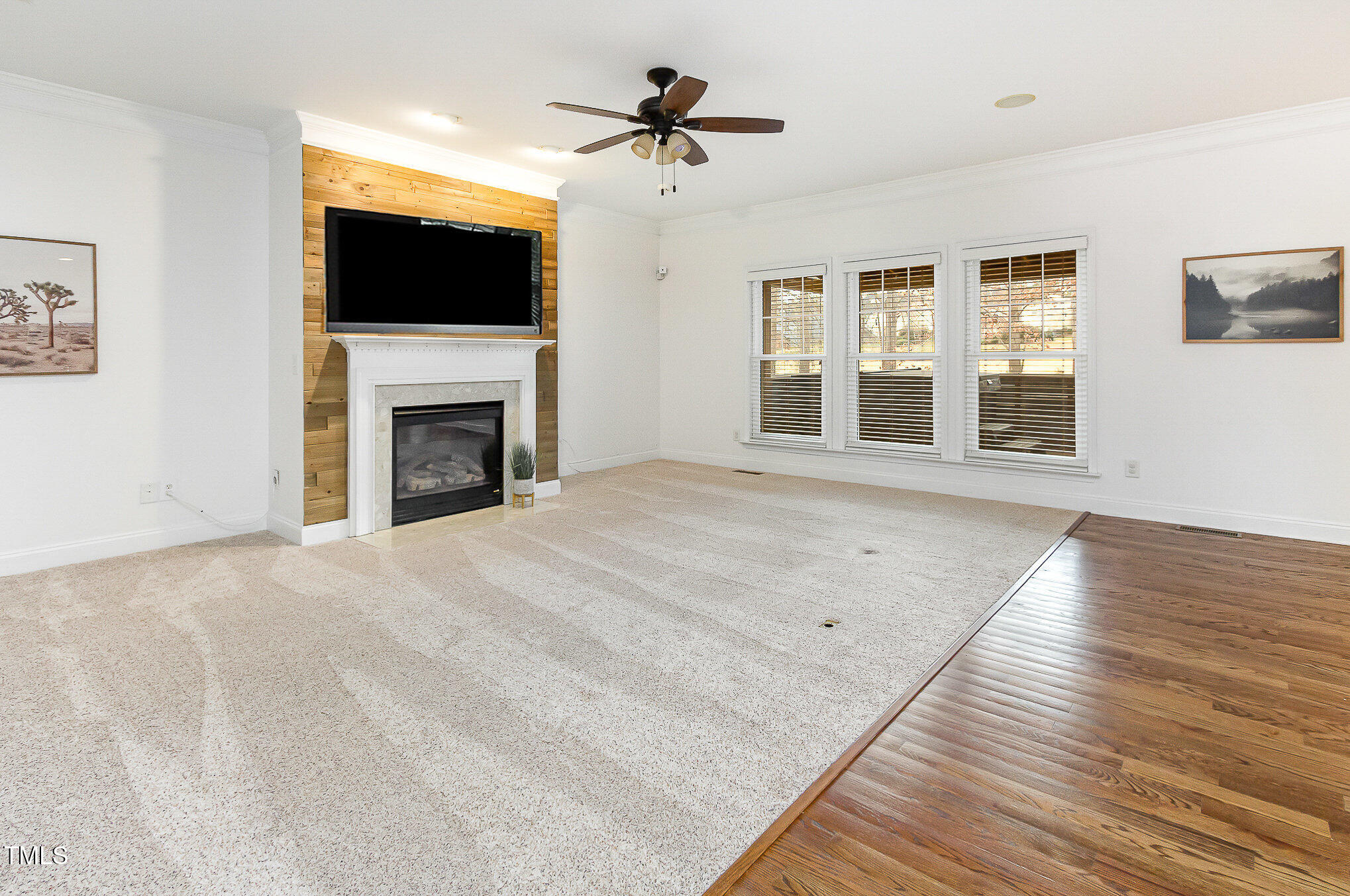405 Challenge Road Raleigh, NC 27603 - Photo 6 of 24 a view of an empty room with wooden floor fireplace and a window