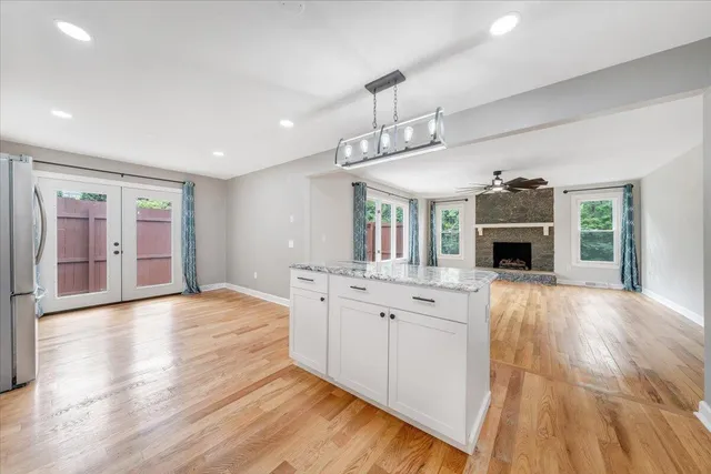a kitchen with granite countertop white cabinets and white appliances