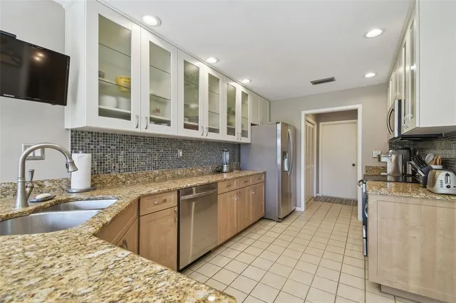 a kitchen with stainless steel appliances granite countertop a stove a sink and a microwave