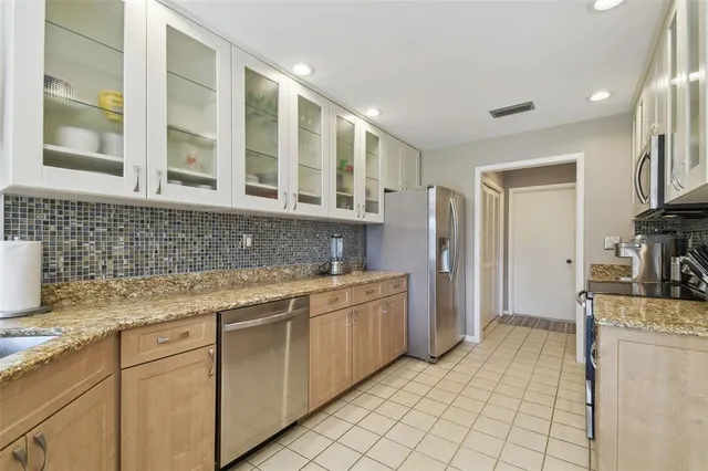 a kitchen with stainless steel appliances granite countertop a refrigerator and a sink