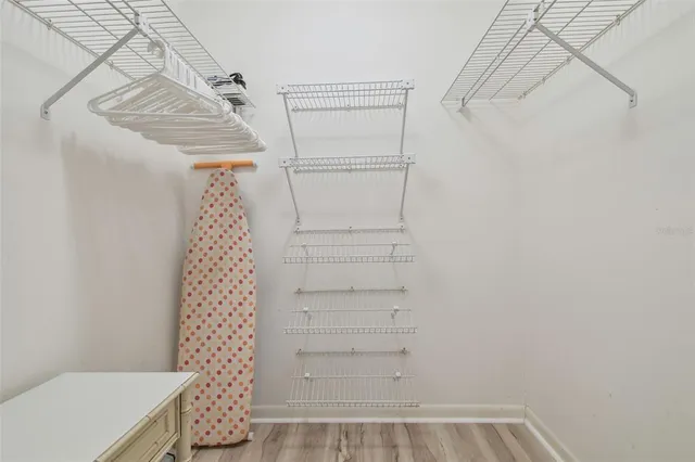 a view of a hallway with wooden floor and windows
