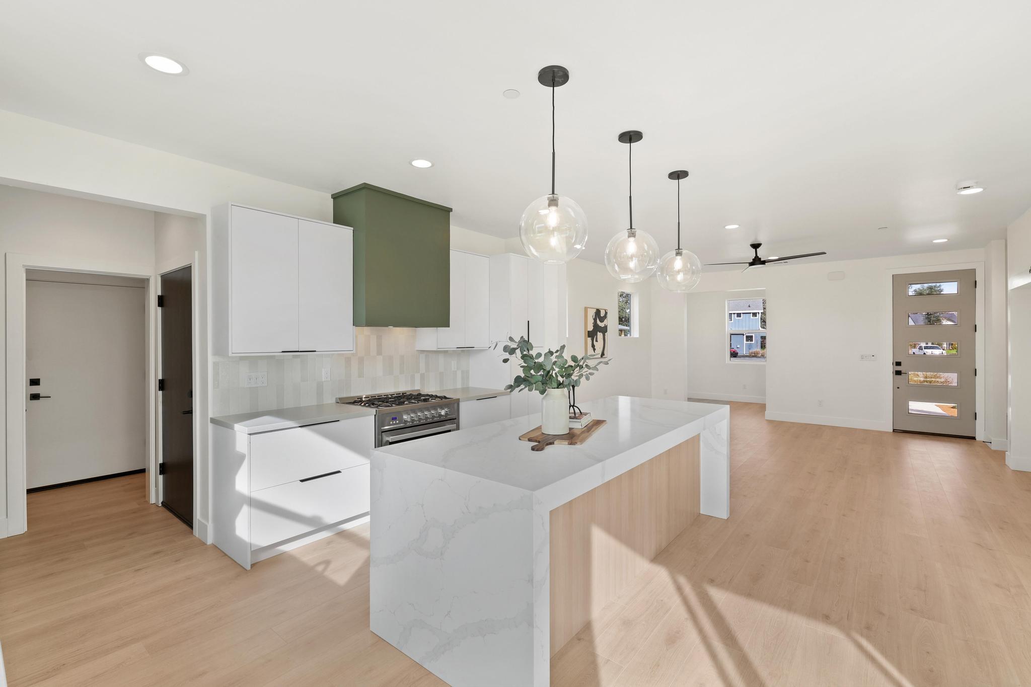 2450 Neighborly Way Redding, CA 96001 - Photo 11 of 48 a view of a kitchen with kitchen island stainless steel appliances a sink a counter top space and living room view
