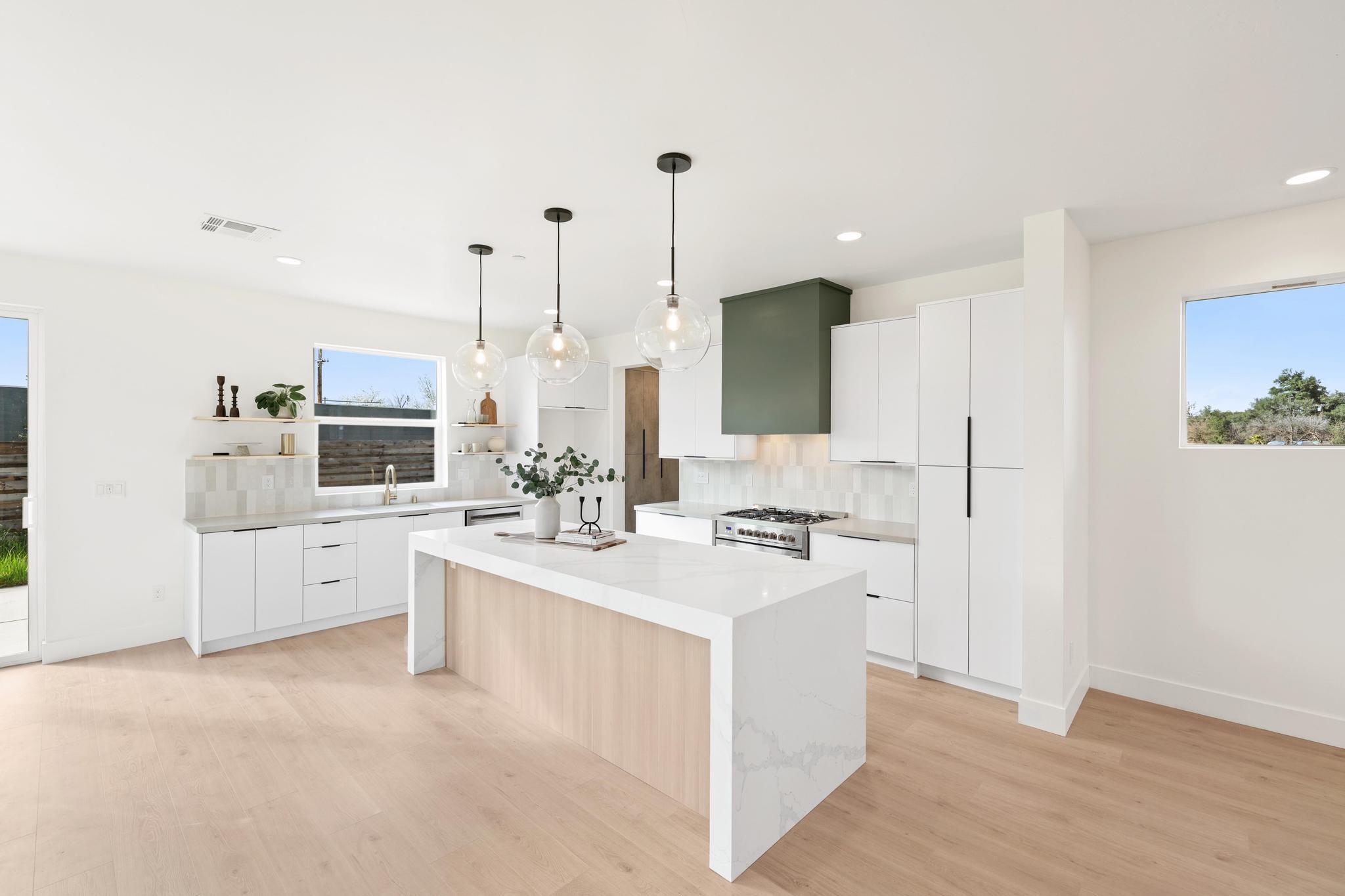2450 Neighborly Way Redding, CA 96001 - Photo 6 of 48 a large white kitchen with a stove a sink a refrigerator and white cabinets with wooden floor