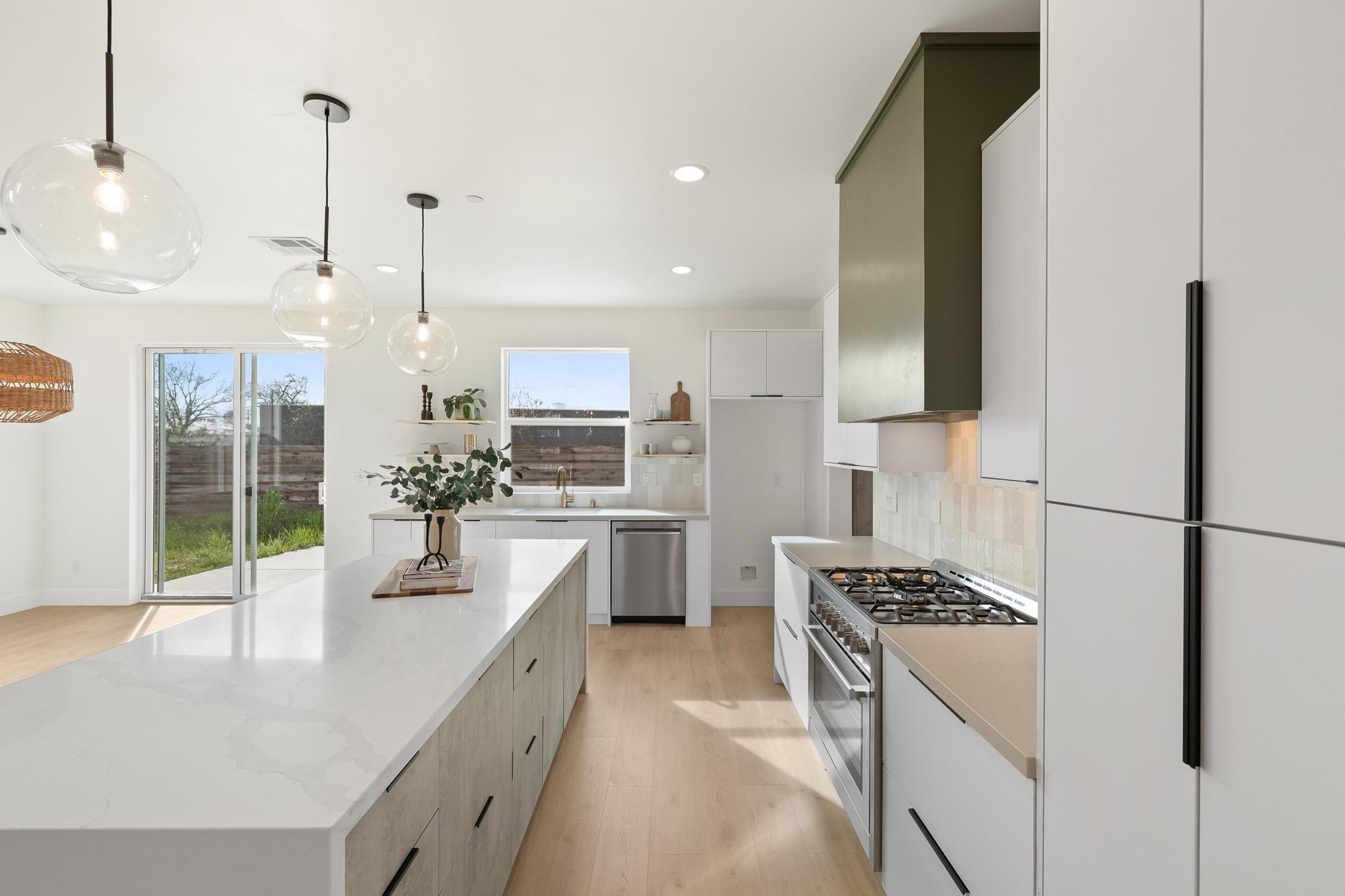 2450 Neighborly Way Redding, CA 96001 - Photo 9 of 48 a large kitchen with kitchen island a large counter top space a sink stainless steel appliances and cabinets
