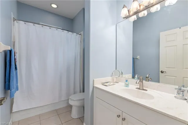 a bathroom with a double vanity sink toilet and a mirror