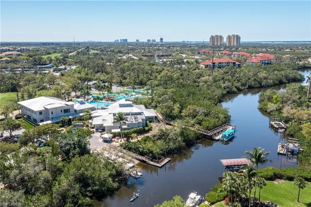 an aerial view of city and lake with trees all around
