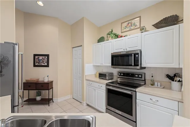 a kitchen with stainless steel appliances a stove a microwave and white cabinets