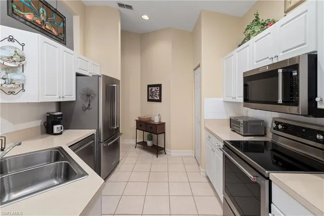a kitchen with stainless steel appliances a stove microwave and refrigerator