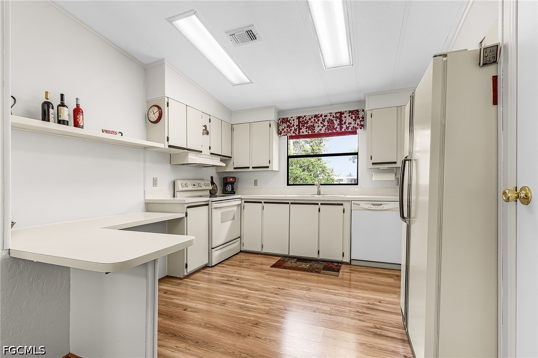 5 Erica Street Alva, FL 33920 - Photo 17 of 37 a kitchen with white cabinets and white appliances