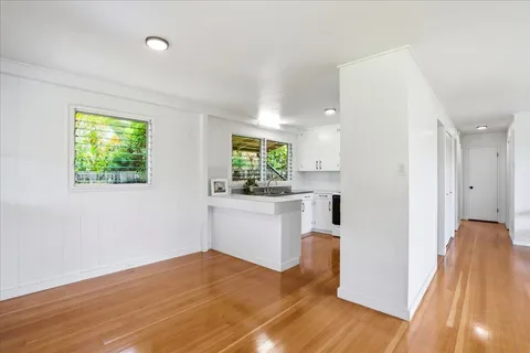a view of a kitchen with wooden floor and a window