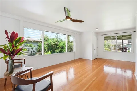 a view of a livingroom with wooden floor and a potted plant