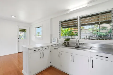 a kitchen with white cabinets and a window