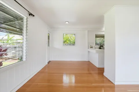 a view of empty room with window and wooden floor