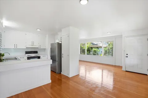 a kitchen with a refrigerator and a stove top oven