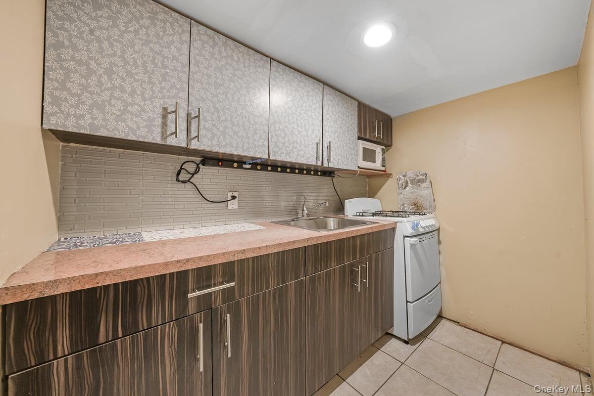 130-24 Springfield Boulevard Queens, NY 11413 - Photo 16 of 20 a kitchen with a sink and cabinets
